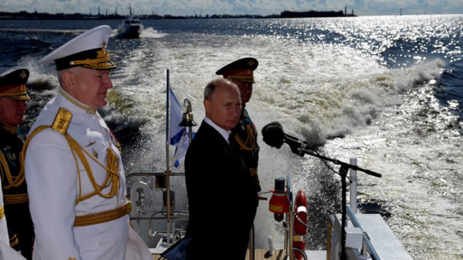 بوتين رفقة وزير الدفاع سيرغي شويغو وقائد سلاح البحرية نيكولاي يفمينوف خلال العرض العسكري في سان بطرسبورغ أمس (أ.ف.ب)