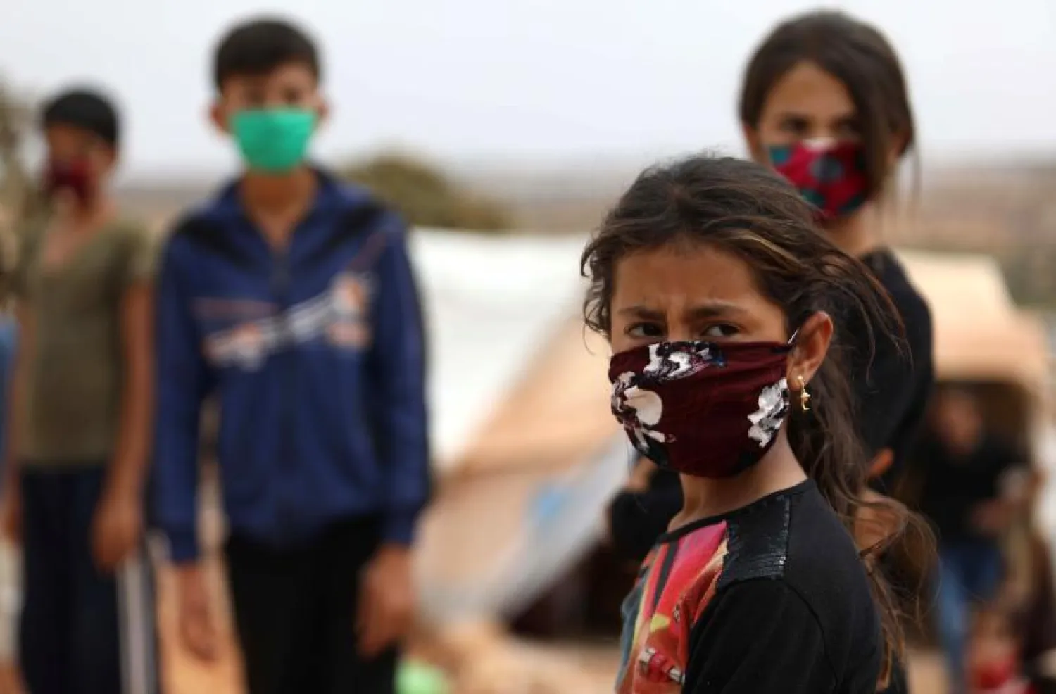 أطفال يرتدون الكمامات في احد مخيمات اللاجئين بسوريا (أ.ف.ب)