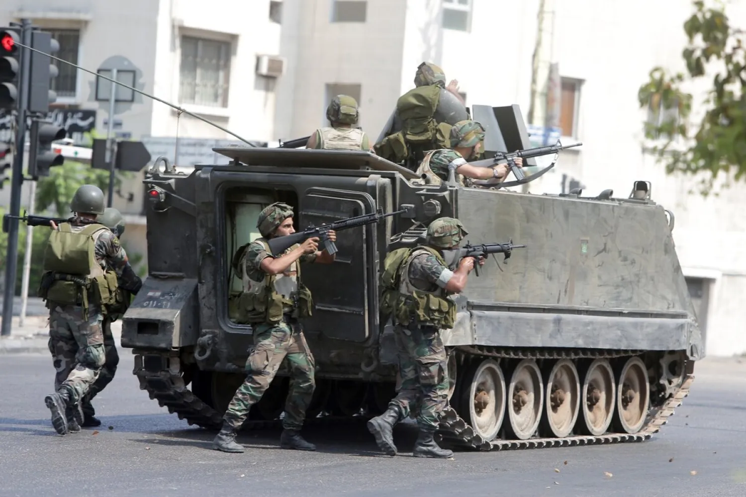  Lebanese soldiers take cover behind their armored vehicle as they enter the Abra neighborhood on the eastern outskirts of Sidon, June 24, 2013. (Joseph Eid/AFP via Getty Images)
