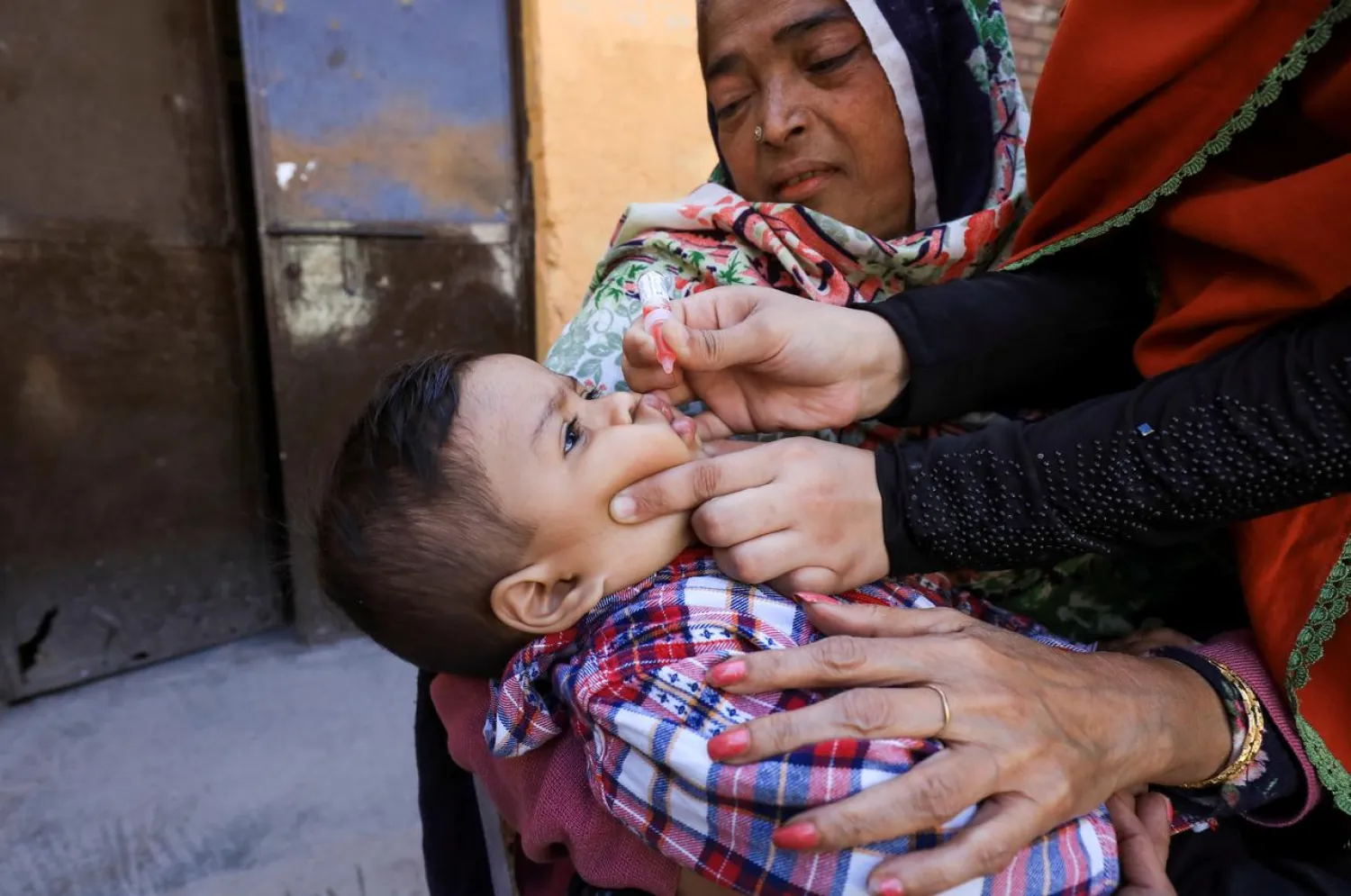 FILE PHOTO: A boy receives polio vaccine drops during an anti-polio campaign in Peshawar, Pakistan February 17, 2020. REUTERS/Fayaz Aziz