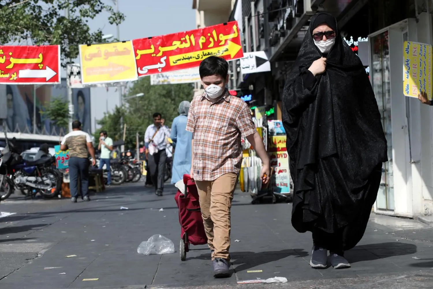 FILE PHOTO: An Iranian woman and her son wearing a protective face mask walks the street, following the outbreak of the coronavirus disease (COVID-19), in Tehran, Iran, June 28, 2020. WANA (West Asia News Agency) via REUTERS