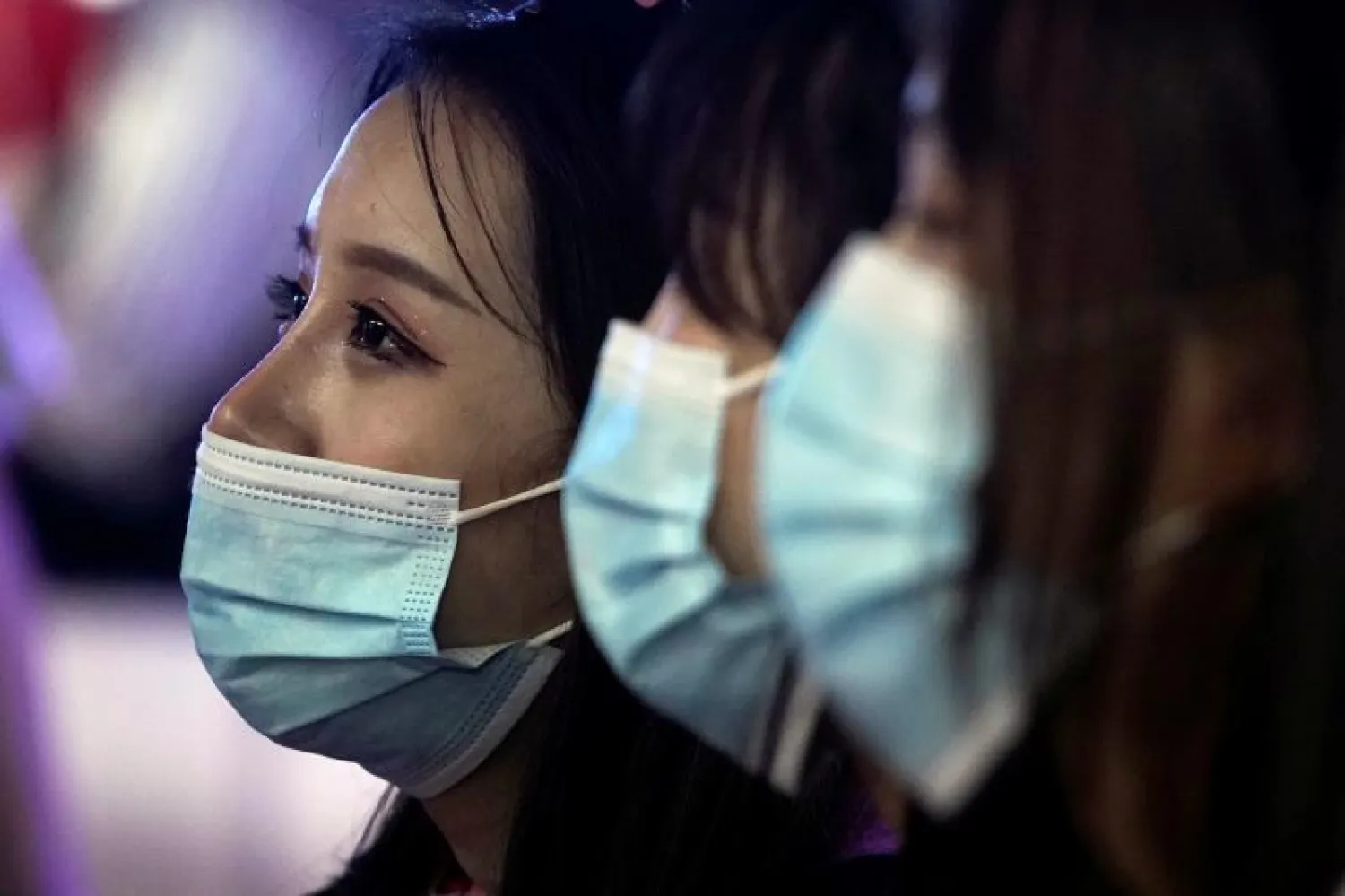 سيدات يضعن كمامات خلال حضورهن مؤتمراً في شنغهاي بالصين (رويترز)