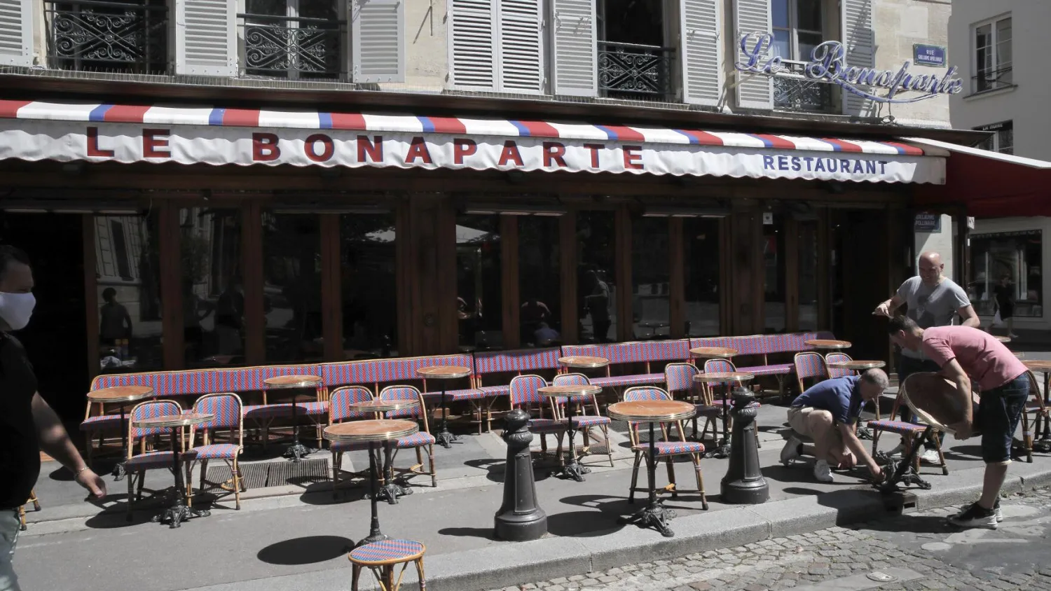 In this June 1, 2020, file photo, waiters prepare the terrace of a restaurant in order to respect distancing measures in Paris as France gradually lifts its lockdown due to the coronavirus. France's economy shrank by nearly 14% in the second quarter when the country was in coronavirus lockdown, a third consecutive quarter of negative growth in a worsening recession, the national statistics agency said Friday, July 31, 2020. (AP Photo/Christophe Ena, File)