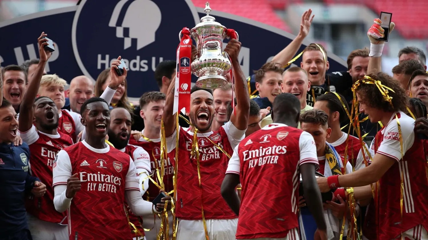 Arsenal’s Pierre-Emerick Aubameyang (C) holds the winner’s trophy as the team celebrates victory after the FA Cup final match against Chelsea at Wembley Stadium in London, on August 1, 2020. (AFP)