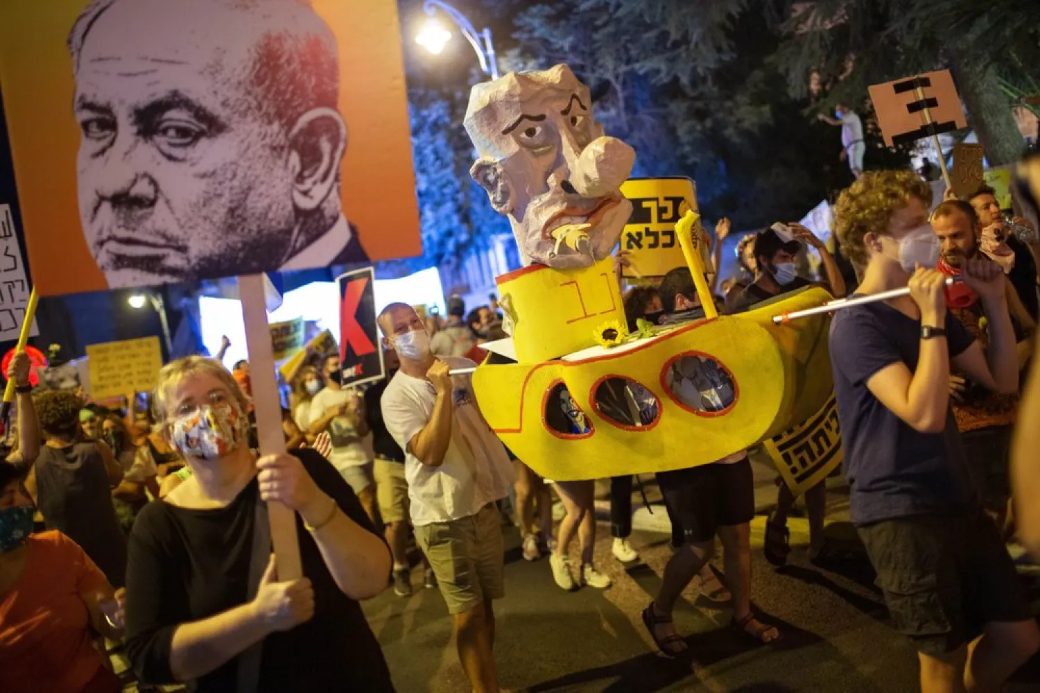 Demonstrators chant slogans and hold signs during a rally against Israel's Prime Minister Benjamin Netanyahu outside his residence in Jerusalem, Saturday, Aug 1, 2020. (AP)