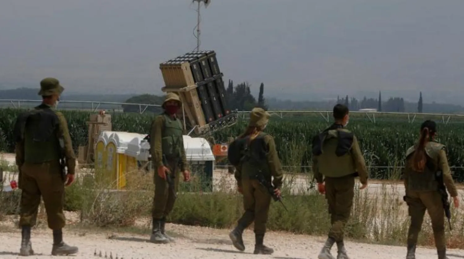 Israeli soldiers stand in front of an Iron Dome defense system battery, designed to intercept and destroy incoming short-range rockets and artillery shells, in the Hula Valley in northern Israel near the border with Lebanon, on July 27, 2020. (Photo by JALAA MAREY / AFP)