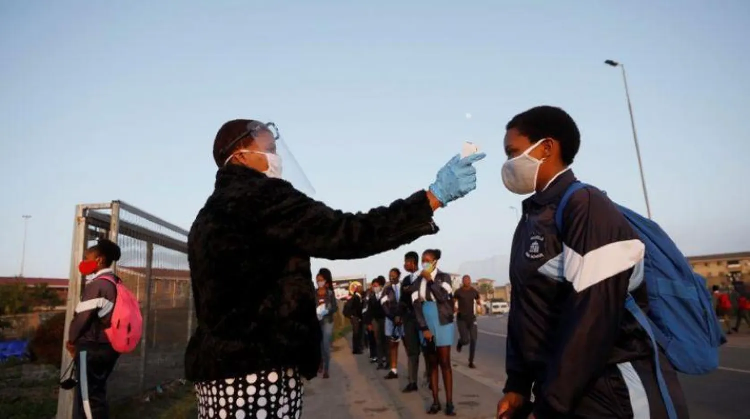 Cape Town'da okula girmeden önce ateşi ölçülen bir öğrenci (Reuters-Arşiv)