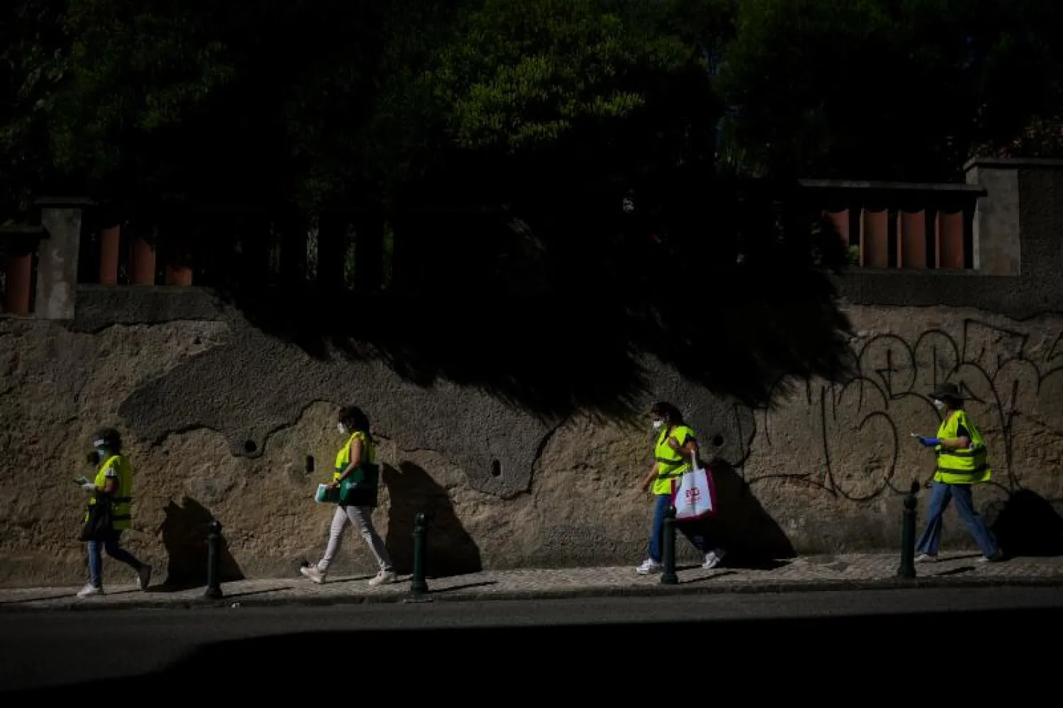 عاملون بلديّون يرتدون معدات الوقاية خلال حملة توعية حول فيروس «كورونا» في ضواحي لشبونة (أ.ف.ب)