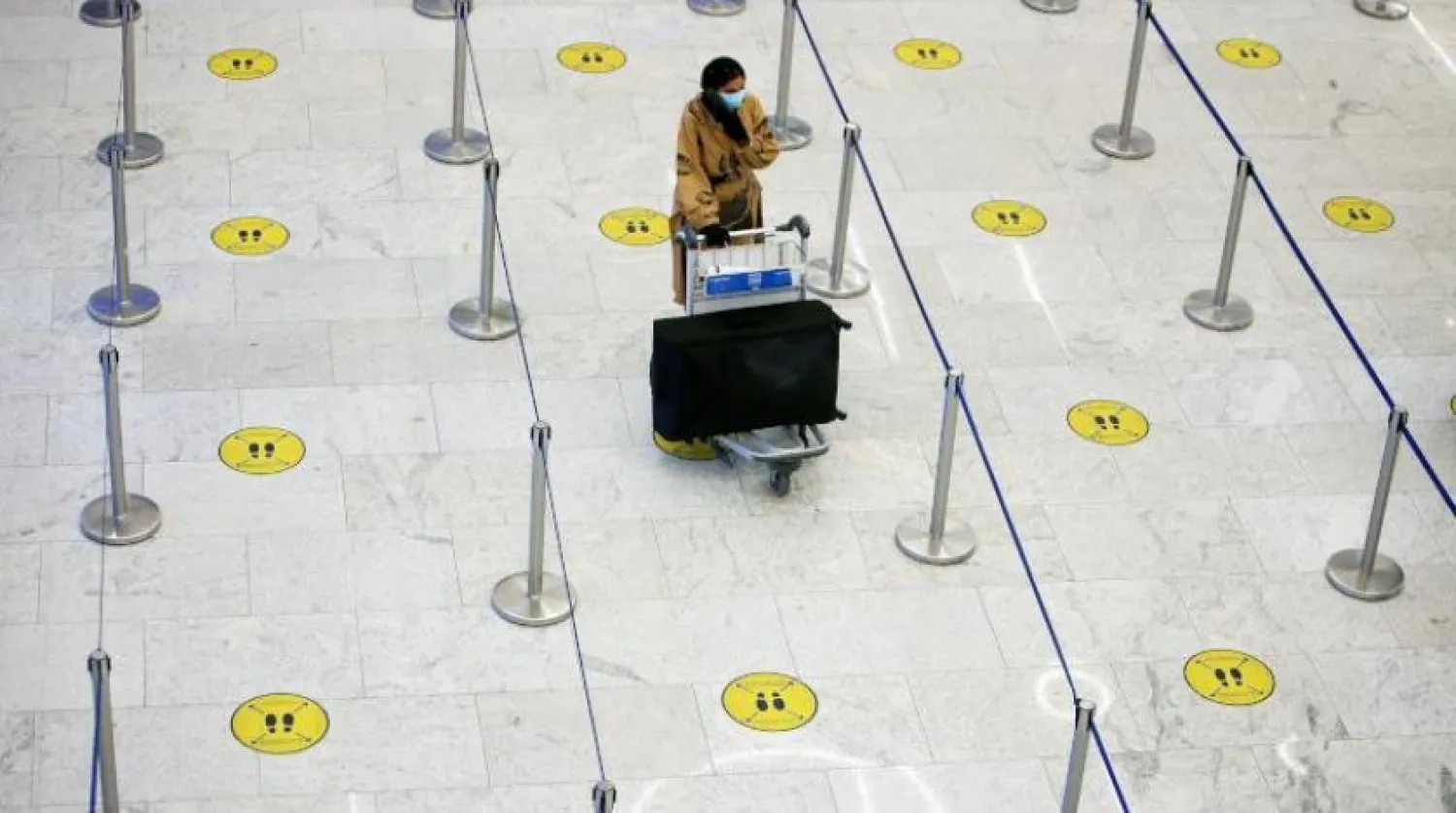 Kuveyt’te koruyucu maske takan bir yolcu (AFP)