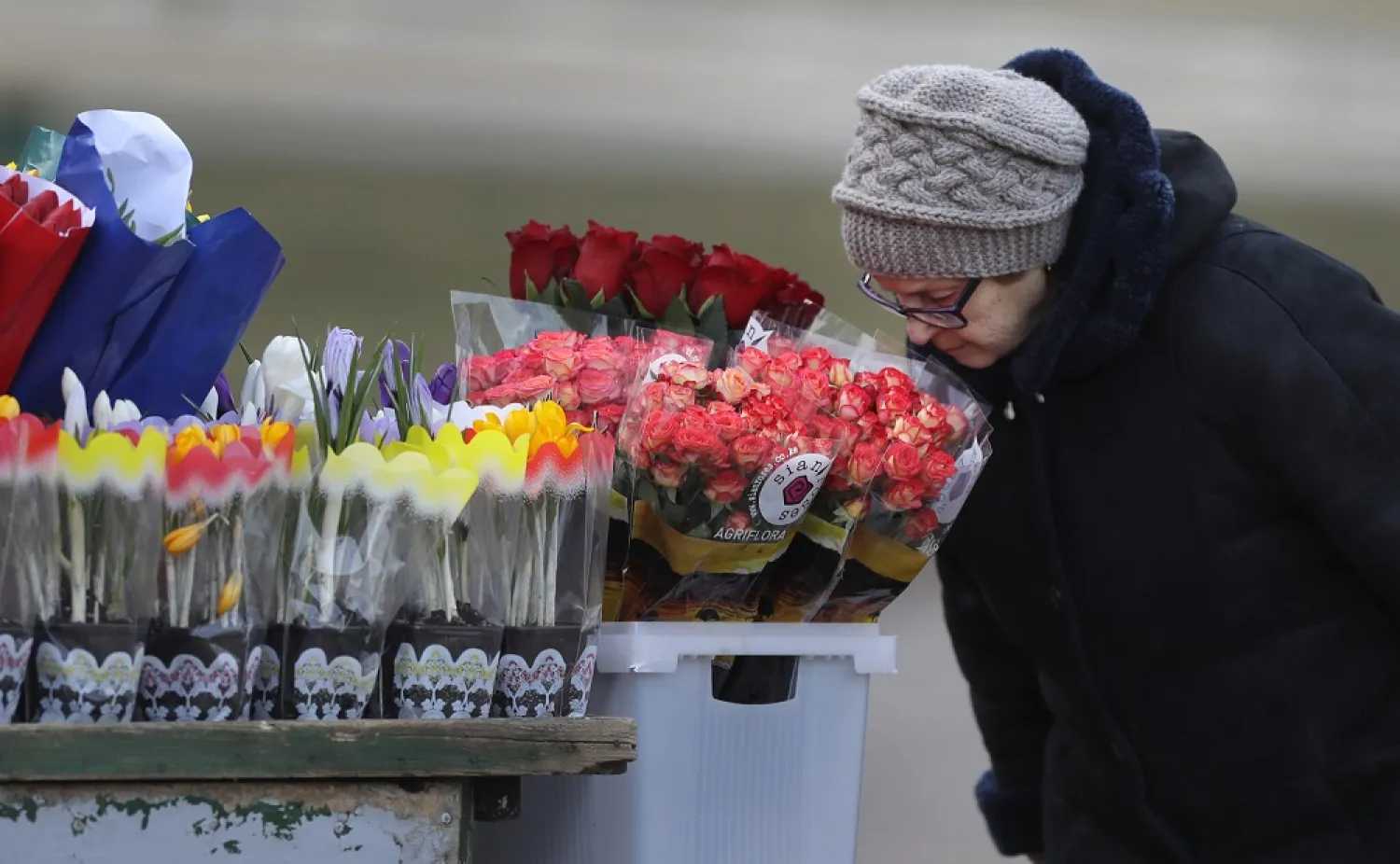 A woman smells the flowers at a street market on the eve of the International Women's Day in Minsk, Belarus on March 7, 2019. (AP)