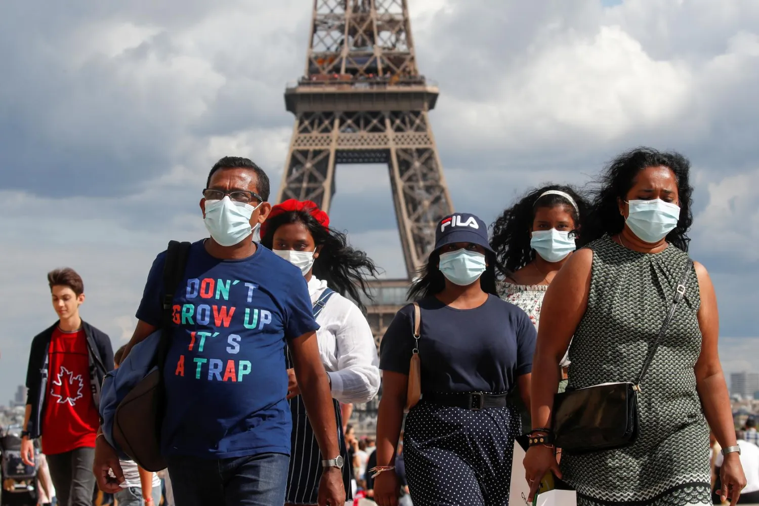 People wearing protective face masks walk at the Trocadero square near the Eiffel Tower in Paris as France reinforces mask-wearing as part of efforts to curb a resurgence of the coronavirus disease (COVID-19) across the country, August 3, 2020. REUTERS/Gonzalo Fuentes
