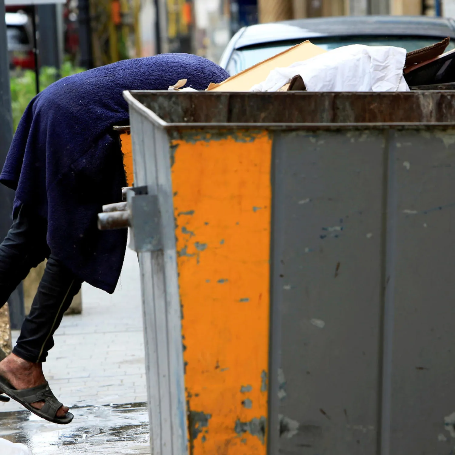 A man searches through a bin during a countrywide lockdown to combat the spread of coronavirus in Sidon, Lebanon, April 1, 2020. © Ali Hashishoa, REUTERS