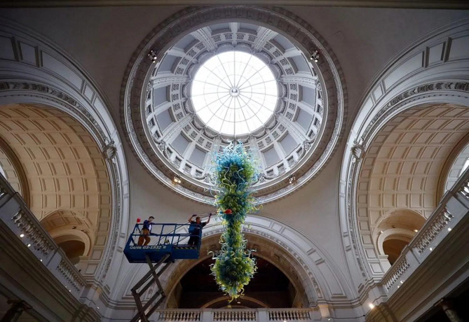 A museum technician cleans the V&A Rotunda Chandelier by Dale Chihuly during preparations to reopen the Victoria & Albert (V&A) Museum. (Reuters)