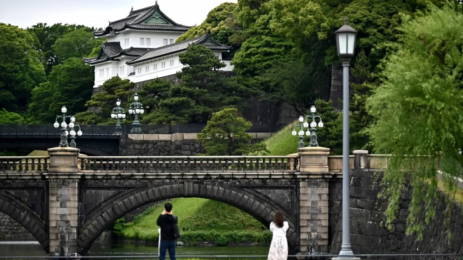 People take pictures of the Imperial Palace, a popular tourist destination, in Tokyo on May 20, 2020. (AFP)
