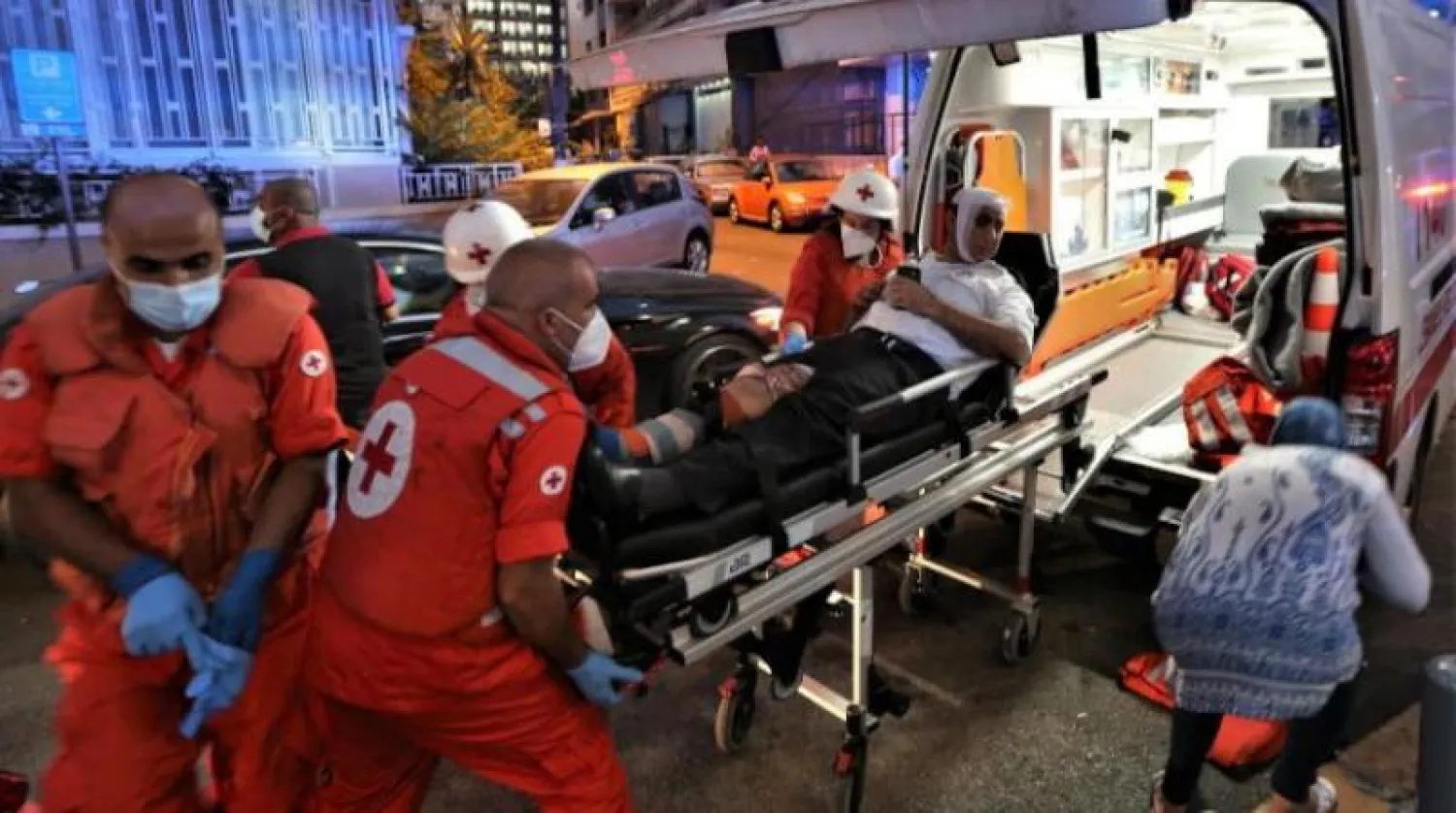 مسعفون ينقلون جريحاً في منطقة الحمرا ببيروت بعد الانفجار الهائل (إ.ب.أ)