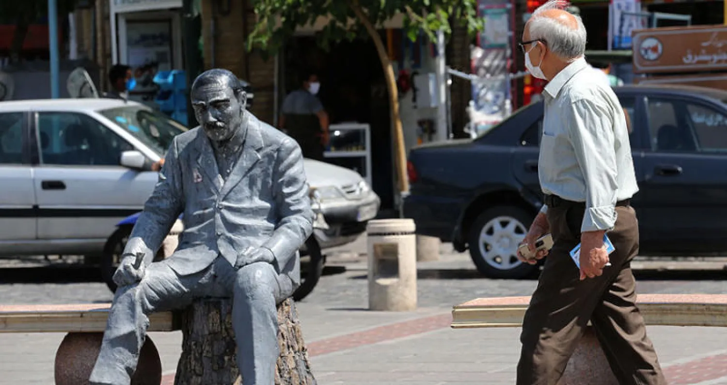 إيراني يرتدي كمامة يقطع شارعاً في سوق «حسن آباد» وسط طهران أول من أمس (أ.ف.ب)