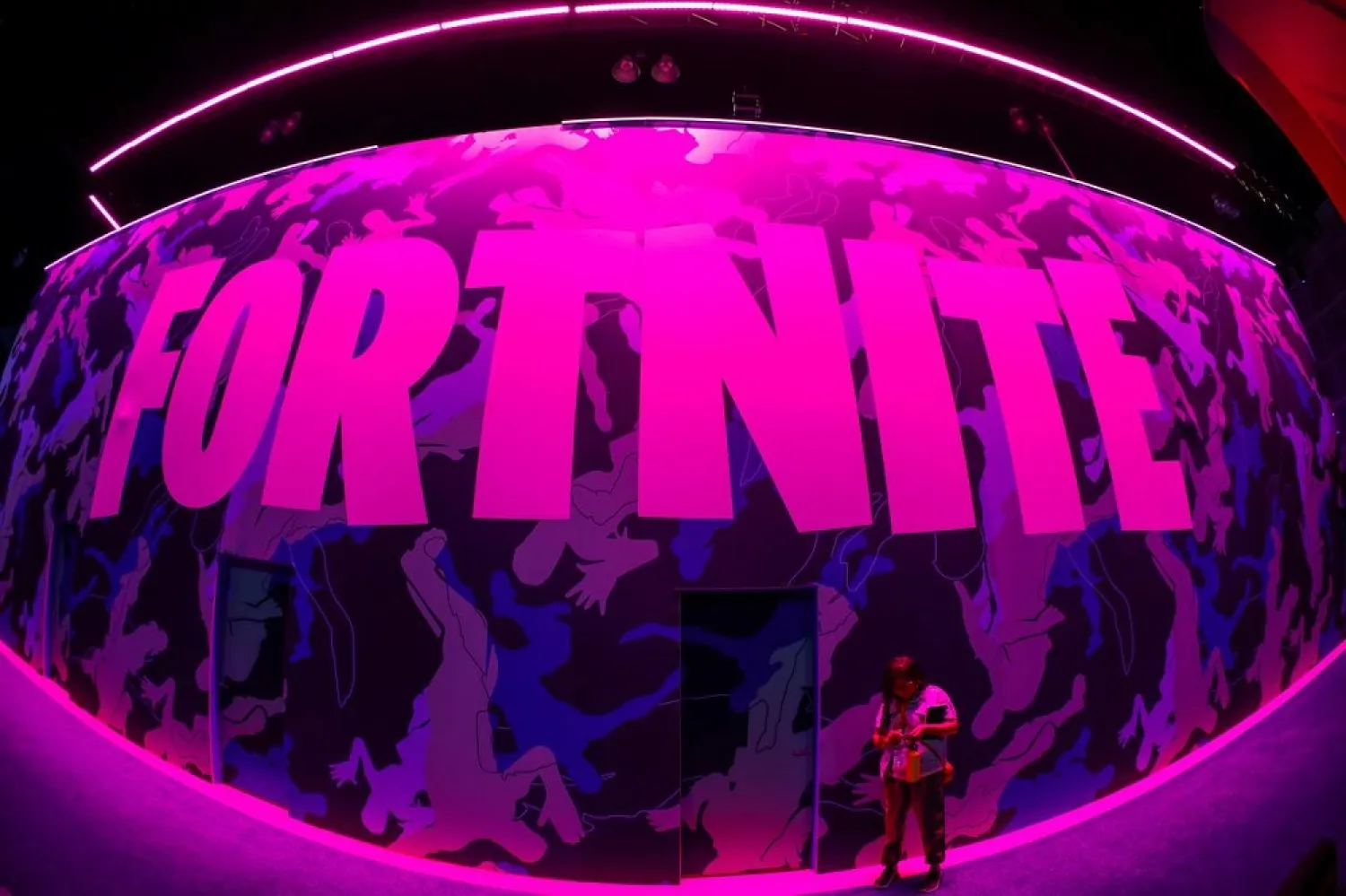 An attendee stops to text next to Epic Games Fortnite sign at E3, the annual video games expo revealing the latest in gaming software and hardware in Los Angeles, California, US, June 12, 2019. (Reuters)