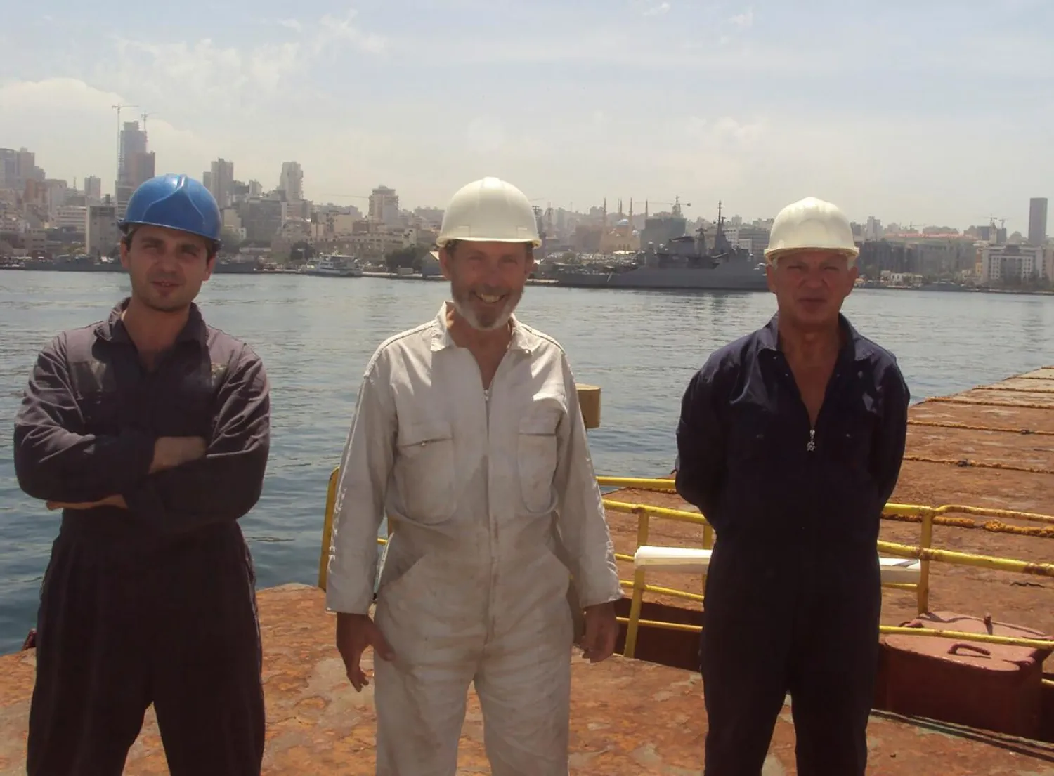 Boris Prokoshev, captain of cargo vessel Rhosus (C), boatswain Boris Musinchak (L) and a crew member pose in the port of Beirut, Lebanon, in a summer 2014 photograph. (Reuters)