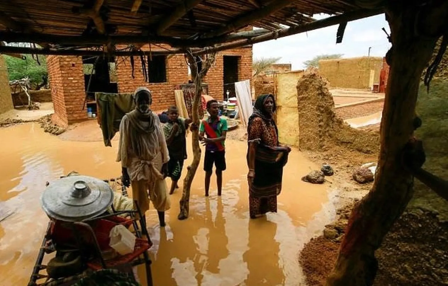 A Sudanese family inspects the damage to their home, after flash floods swept through the town of Umm Dawan Ban, southeast of the capital Khartoum, earlier this week. AFP