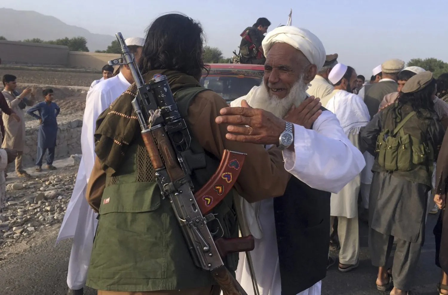 FILE - In this June 16, 2018 file photo, Taliban fighters gather with residents to celebrate a three-day cease fire marking the Islamic holiday of Eid al-Fitr, in Nangarhar province, east of Kabul, Afghanistan. AP