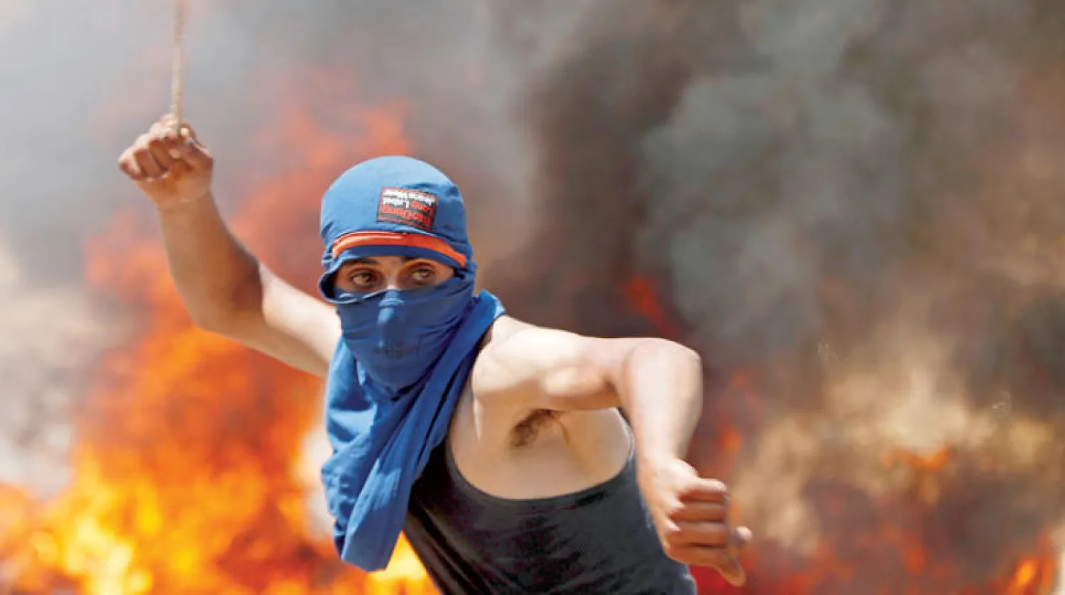 فلسطيني يشارك في احتجاجات ضد الاستيطان الإسرائيلي قرب رام الله أمس (رويترز)