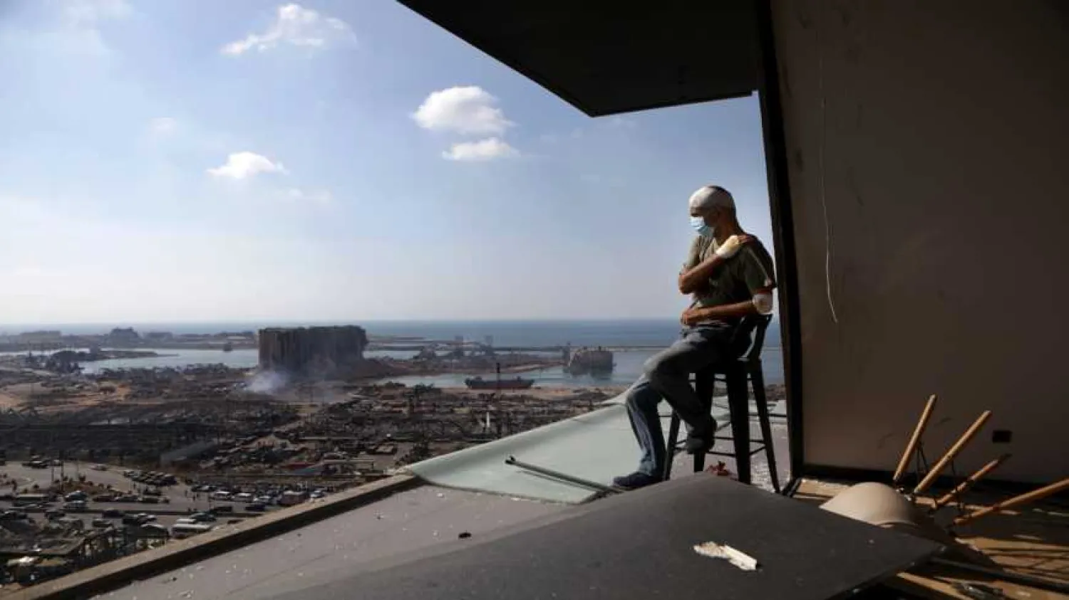 Lebanese TV producer Tony Ahwaji sits injured on the balcony of his damaged apartment in the damaged neighborhood of Mar Mikhael in the Lebanese capital Beirut on Aug. 6, 2020. Photo by PATRICK BAZ/AFP via Getty Images.