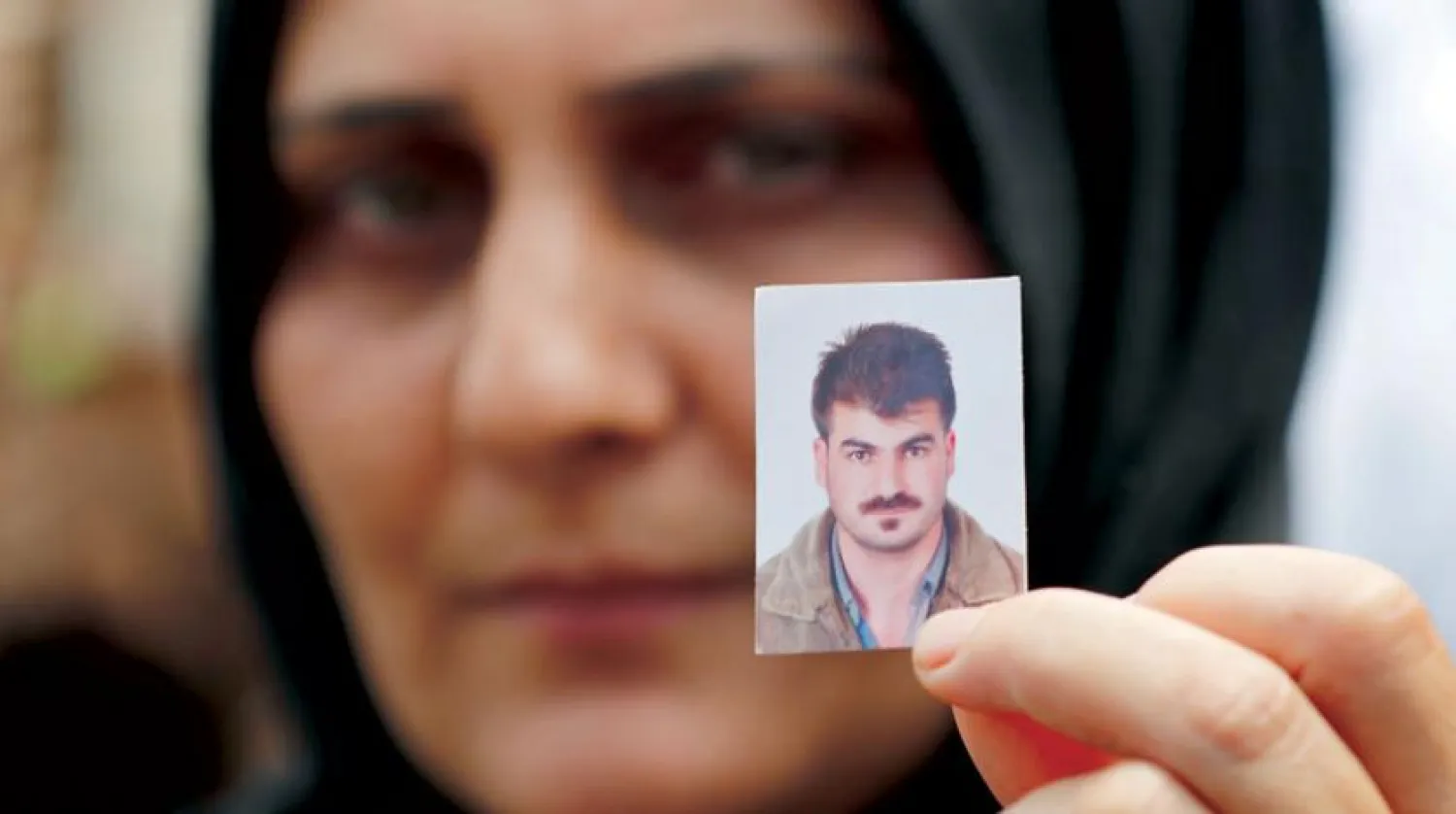  A Lebanese woman a picture of her missing husband. (AP)