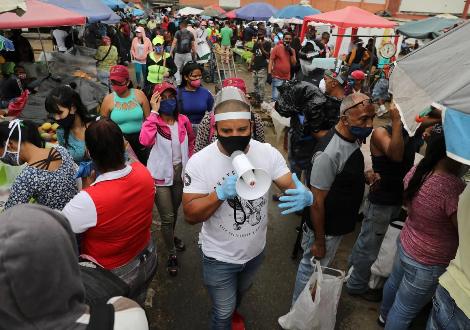 FILE PHOTO: Walter Rivera, director of the Coche wholesale market shouts the rules to prevent the coronavirus (COVID-19) disease to sellers and customers amid the outbreak in Caracas, Venezuela July 23, 2020. REUTERS/Manaure Quintero