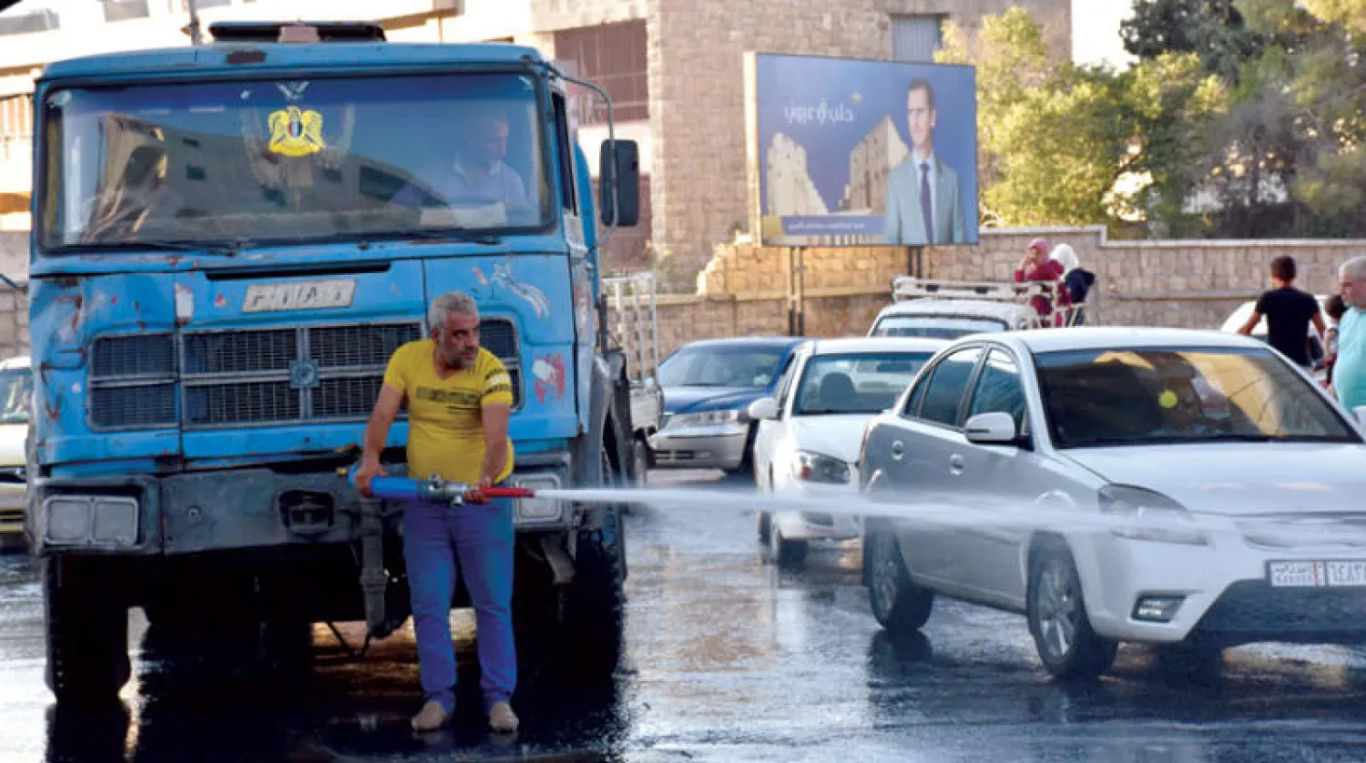 موظف من بلدية حلب يعقم أحد شوارع المدينة (أ.ف.ب)