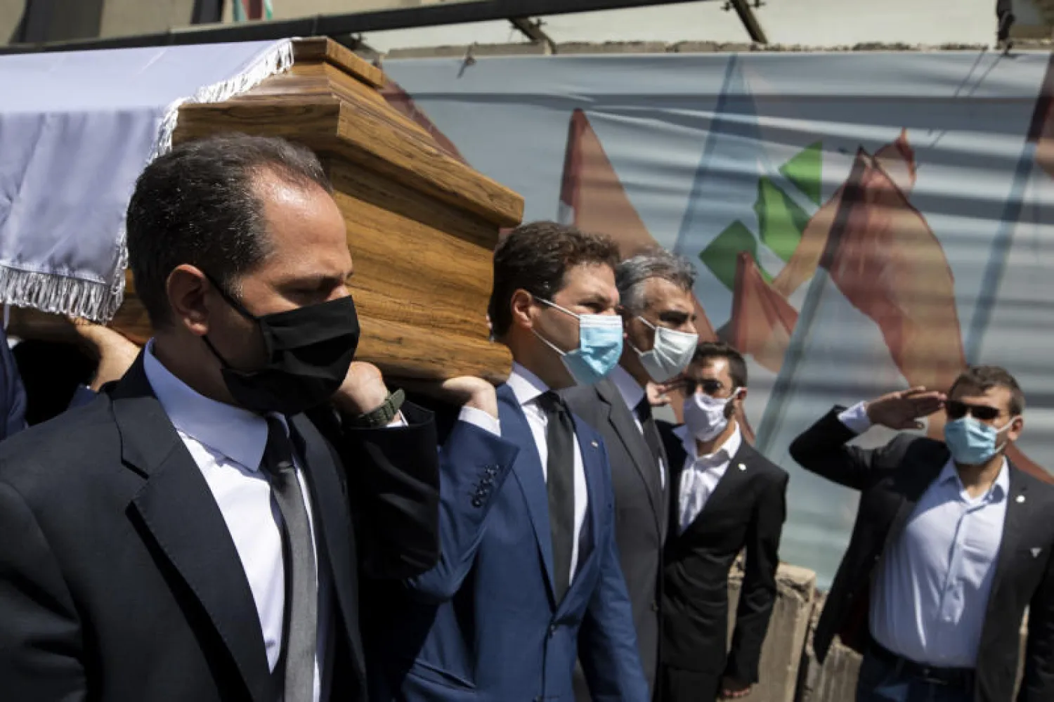 رئيس حزب الكتائب اللبنانية سامي الجميل (يسار) والنائب نديم الجميل يحملان نعش الأمين العام للحزب نزار نجاريان (أ.ب)