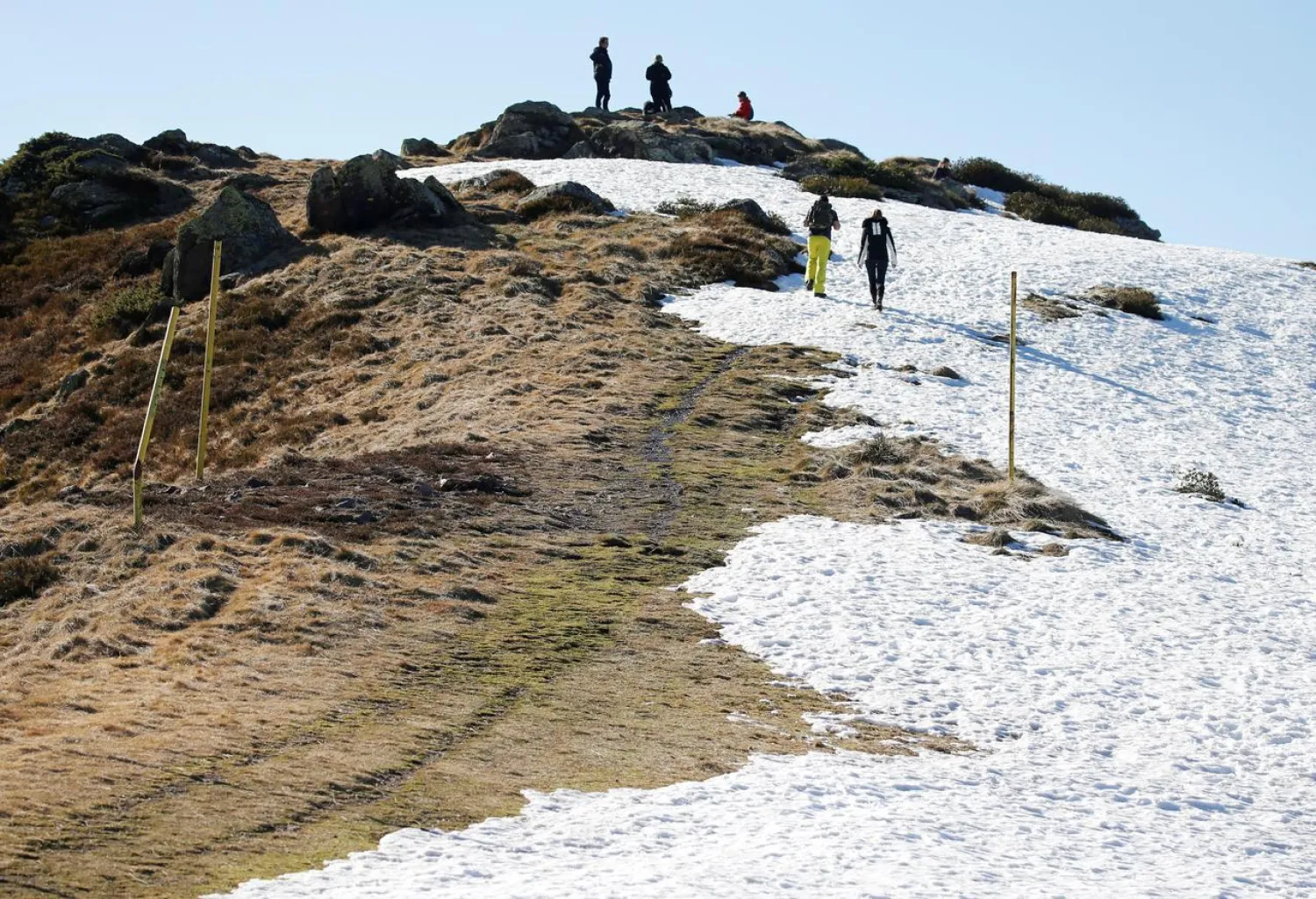 Tourists walk on ski slopes closed due to lack of snow, at a ski resort in Boutx, France, February 10, 2020. REUTERS/Regis Duvignau
