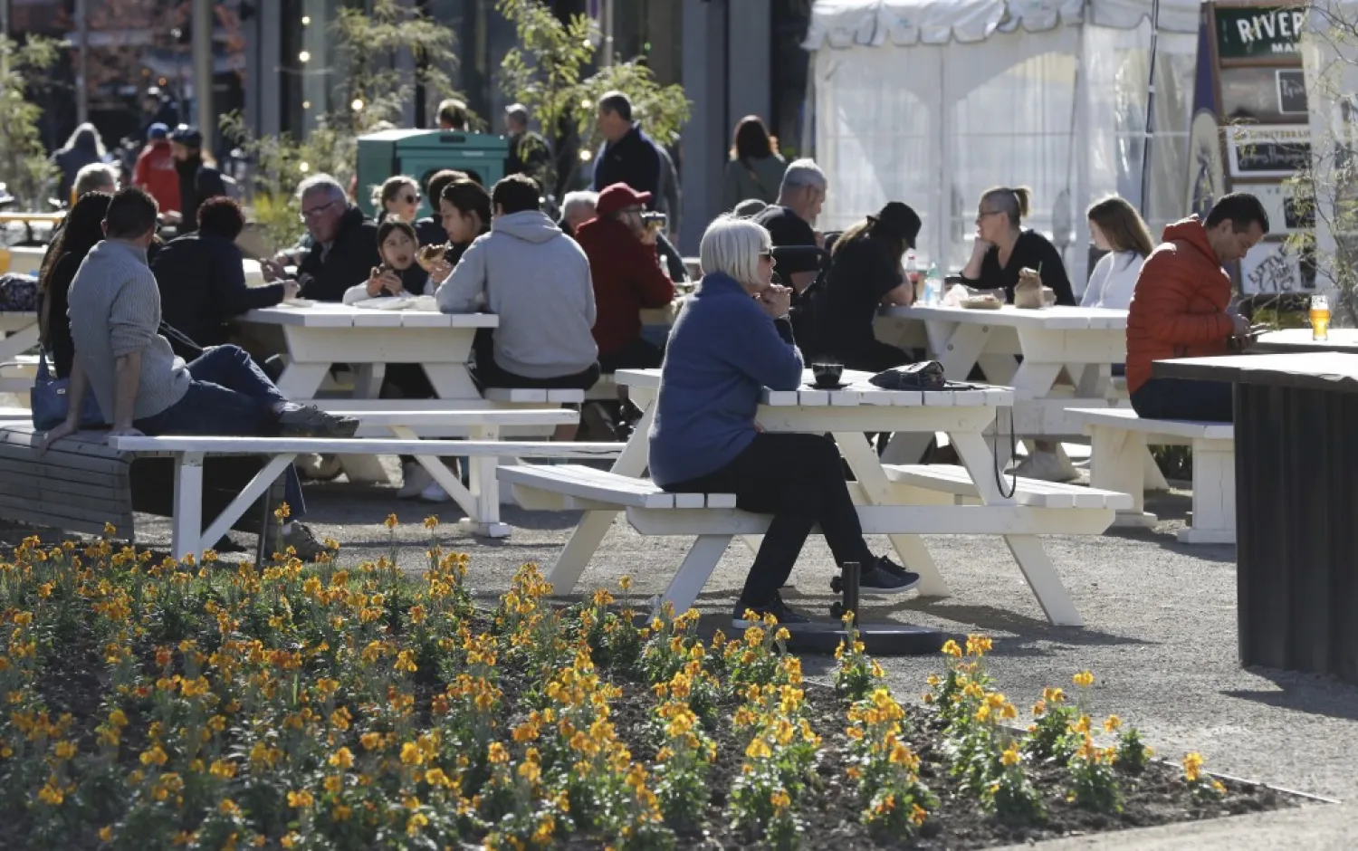Customers enjoy lunch in the sunshine at the Riverside Market in Christchurch, New Zealand, Sunday, Aug. 9, 2020. New Zealand marked a 100 days of being free from the coronavirus in its communities Sunday, Aug. 9, with just a handful of infections continuing to be picked up at the border where people are quarantined. (AP Photo/Mark Baker)