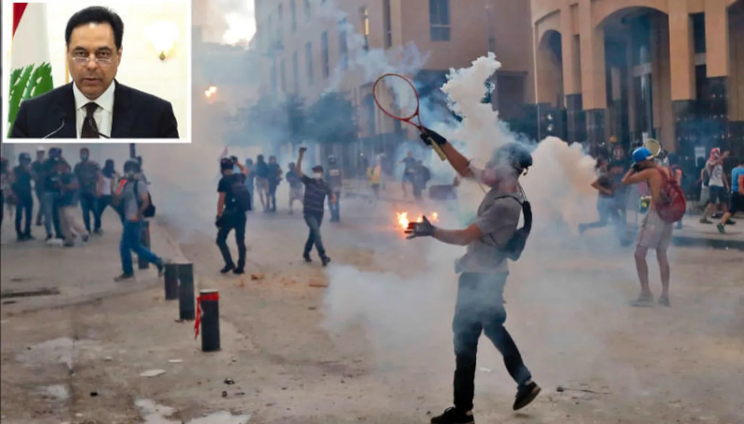 مواجهات بين شبان لبنانيين غاضبين وقوى الأمن وسط بيروت أمس... وفي الإطار حسان دياب معلناً في خطاب متلفز استقالة حكومته (أ.ف.ب)