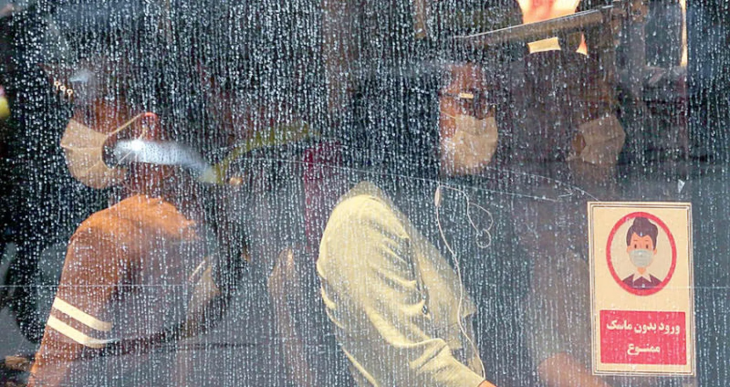 إيرانيان على متن حافلة وسط موجة جديدة من الفيروس في طهران (أ.ف.ب)