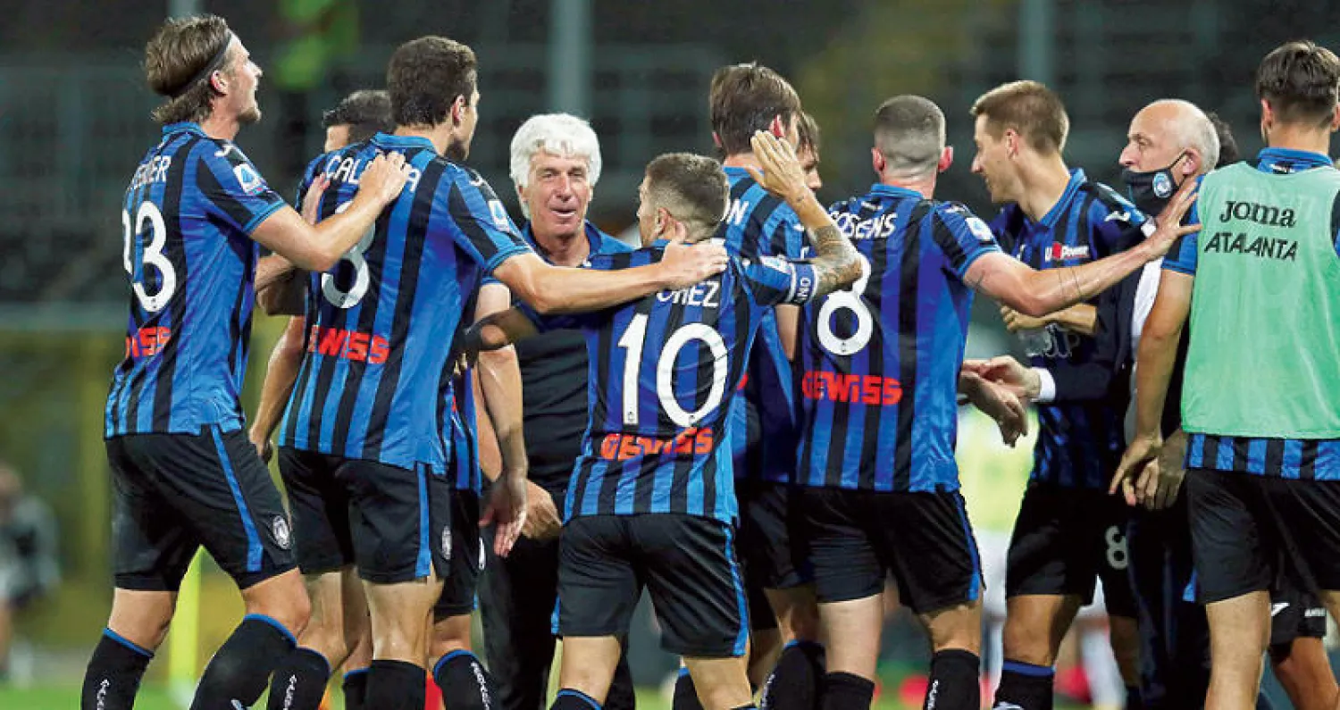 لاعبو أتالانتا يحيطون بمدربهم غاسبريني الذي قادهم لموسم استثنائي (إ.ب.أ)