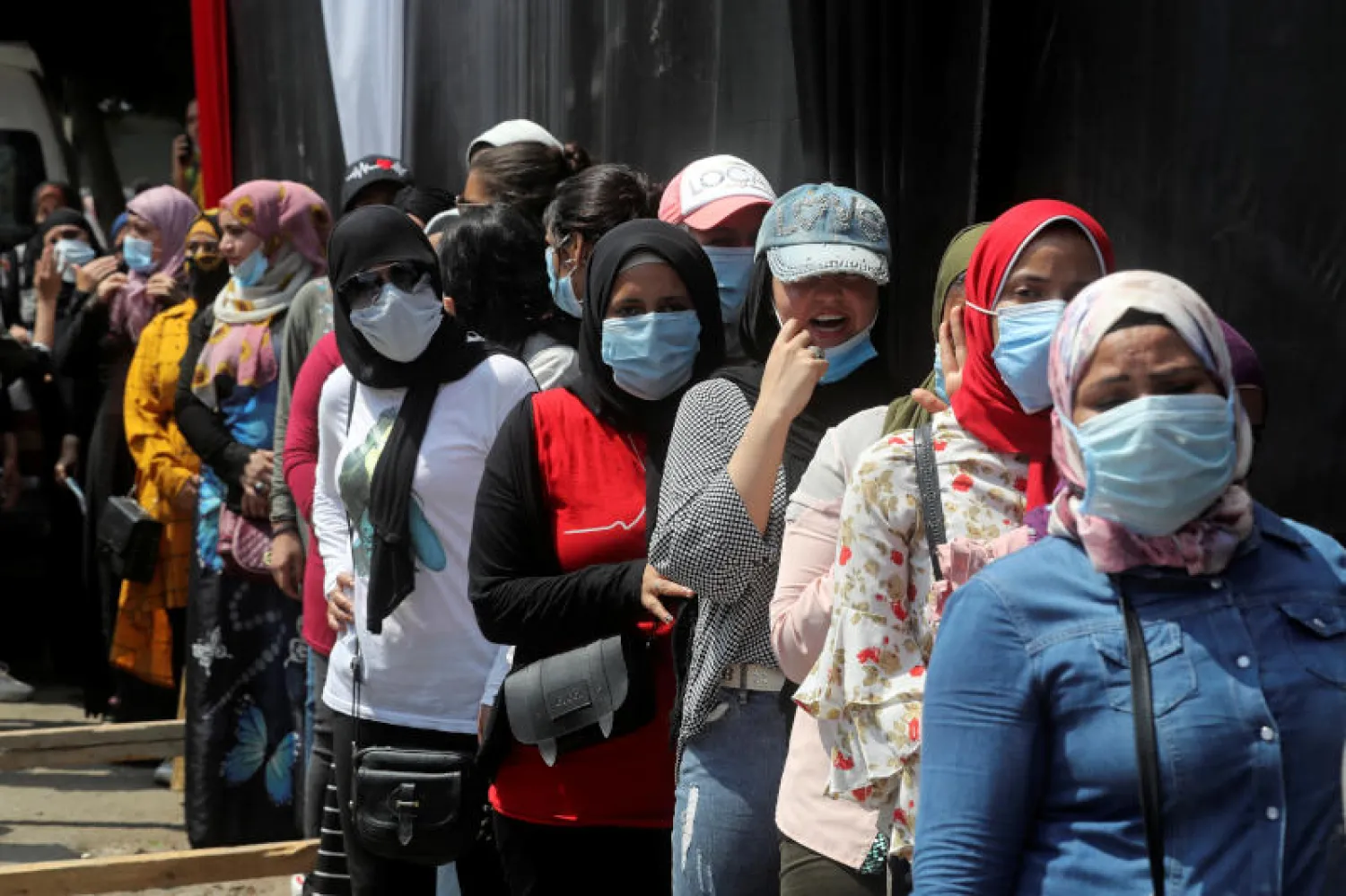 سيدات يقفن في طابور أمام أحد مراكز التصويت في القاهرة (رويترز)