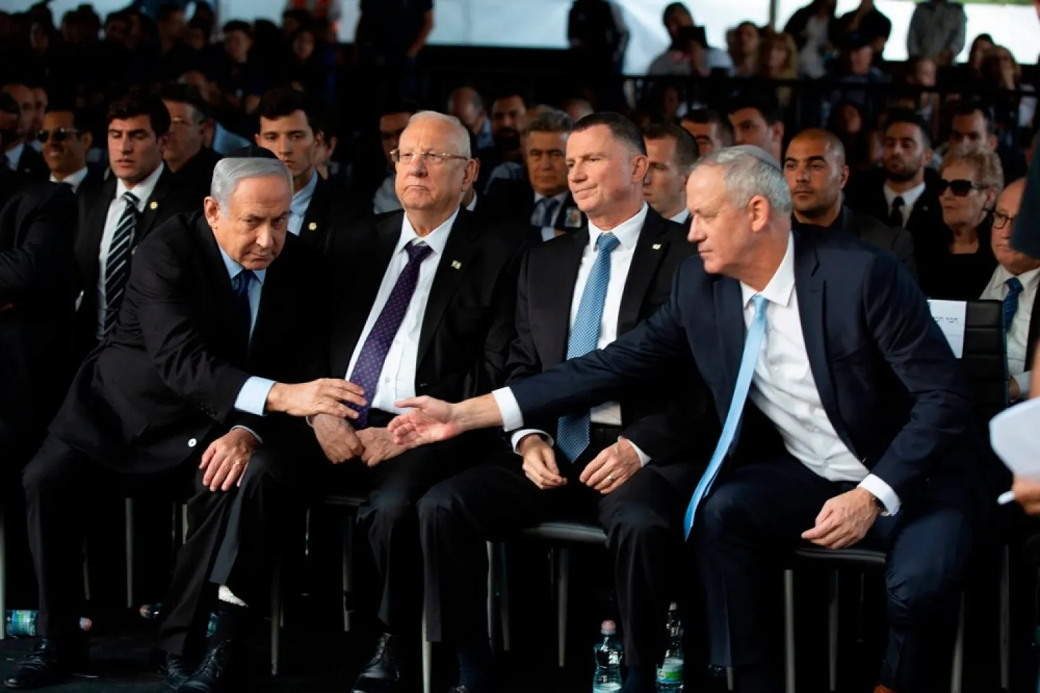 Israeli Blue and White party chief Benny Gantz (R), shakes hands with Prime Minister Benjamin Netanyahu (L) as they attend a ceremony in Jerusalem in November 2019. (Getty Images)