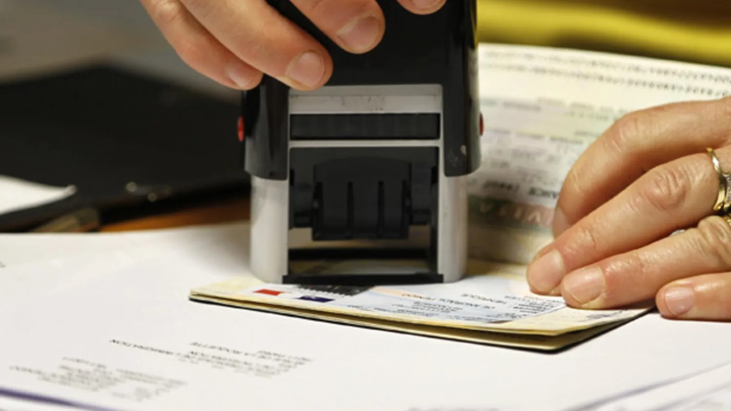  An officer validates a visa on a student's passport (Charles Platiau/ Reuters)
