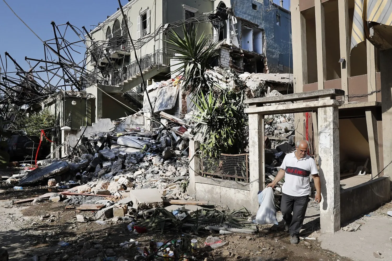 A Lebanese man carries his belongings as he leaves his destroyed house near the scene where an explosion hit the seaport of Beirut, Lebanon, seen on August 6, 2020. (AP)