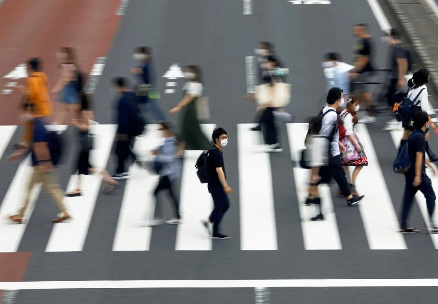 A man wearing a protective face mask crosses the street amid the coronavirus disease (COVID-19) outbreak in Tokyo, Japan July 30, 2020. (Reuters)