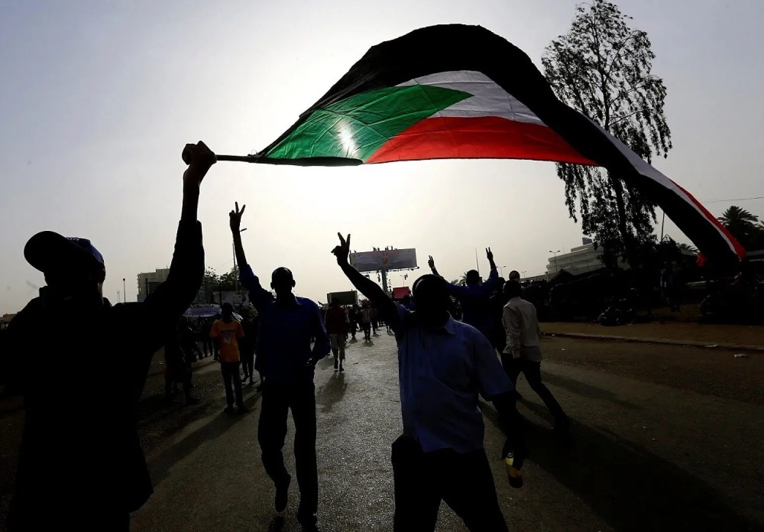 Demonstrators wave their national flag as they arrive for a protest rally demanding president Bashir to step down outside the Defense Ministry in Khartoum, Sudan April 11, 2019. (Reuters)