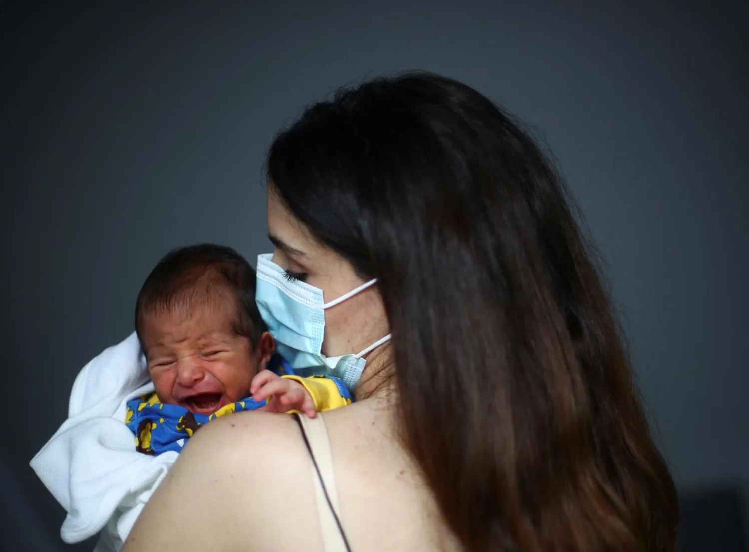 Emmanuelle Lteif Khnaisser who was in labor at the moment of the Beirut port blast, holds her baby George at the family home in Jal al-Dib, Lebanon, August 12, 2020. (Reuters)