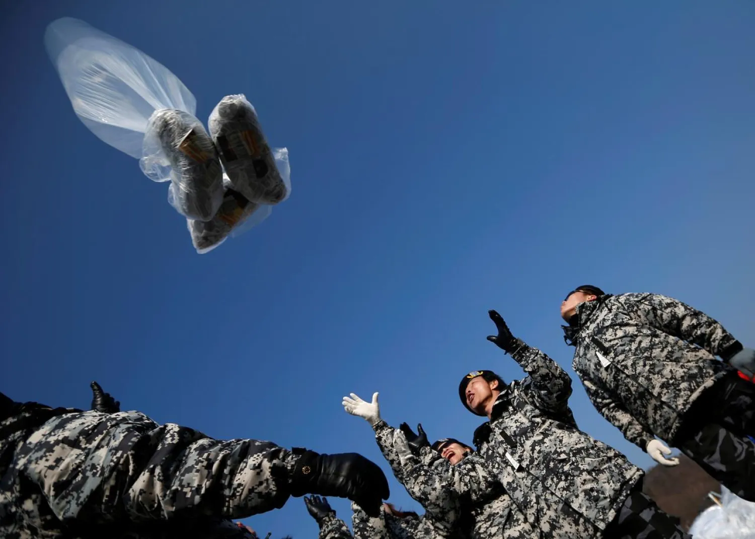 Former North Korean defectors release a balloon containing one dollar banknotes, radios, CD and leaflets denouncing the North Korean regime towards the north, in Paju January 15, 2014. (Reuters)
