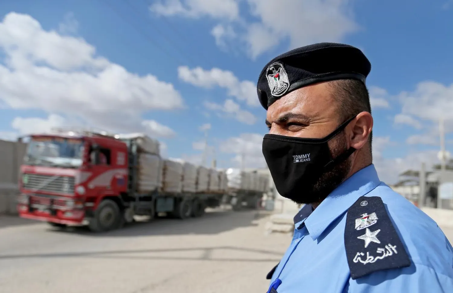 A Palestinian police officer stands outside the main commercial crossing with Gaza, Kerem Shalom, in the southern Gaza strip August 11, 2020. REUTERS/Ibraheem Abu Mustafa