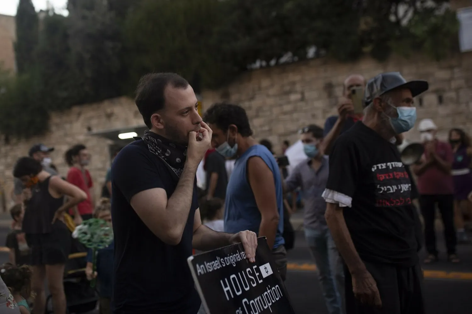 Shachar Oren, 25, whistles during a protest against Israel's Prime Minister Benjamin Netanyahu outside his residence in Jerusalem, Tuesday, Aug. 4, 2020. (AP)