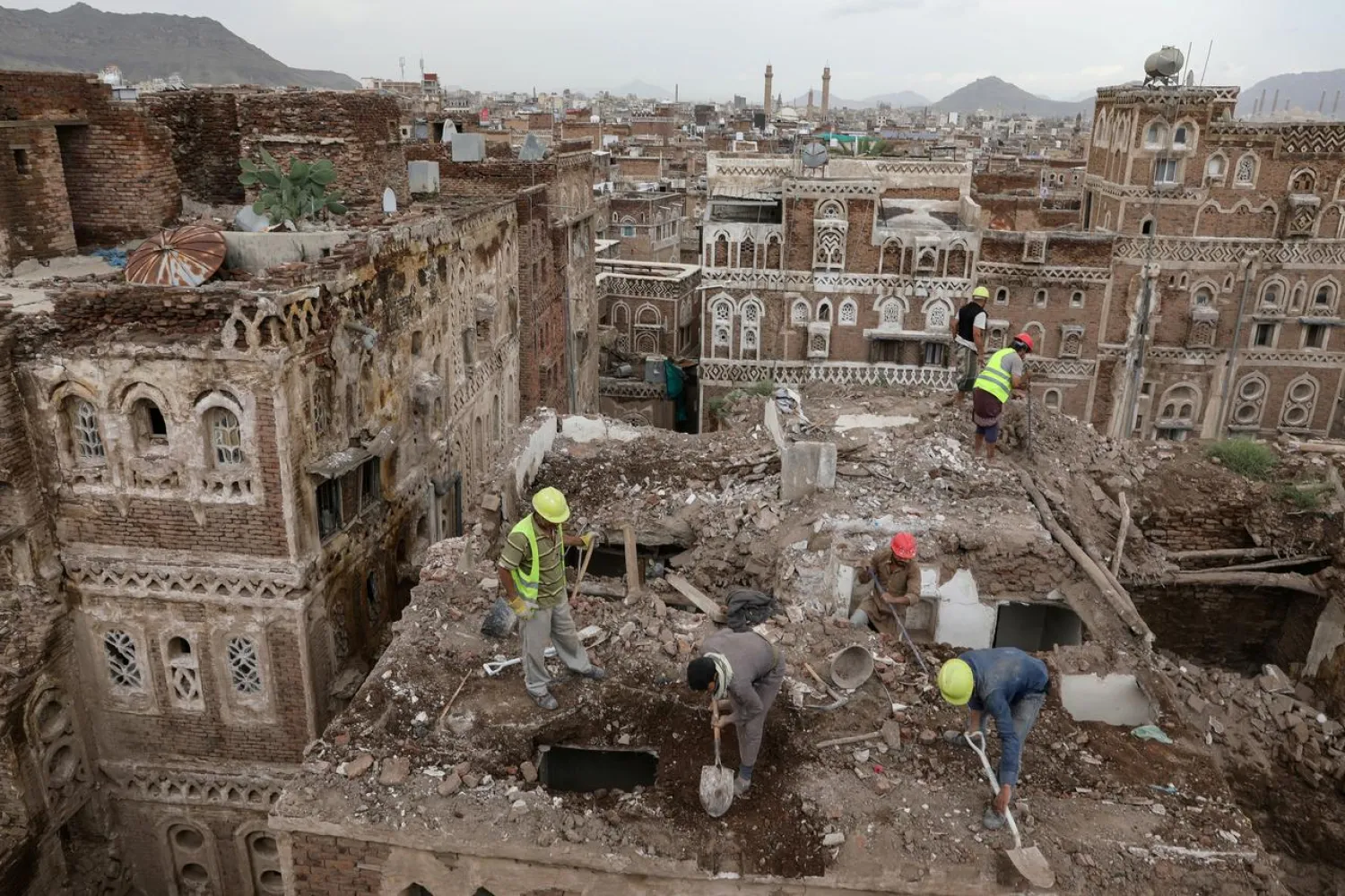 Workers demolish a building damaged by rain in the UNESCO World Heritage site of the old city of Sanaa, Yemen August 9, 2020. REUTERS/Khaled Abdullah