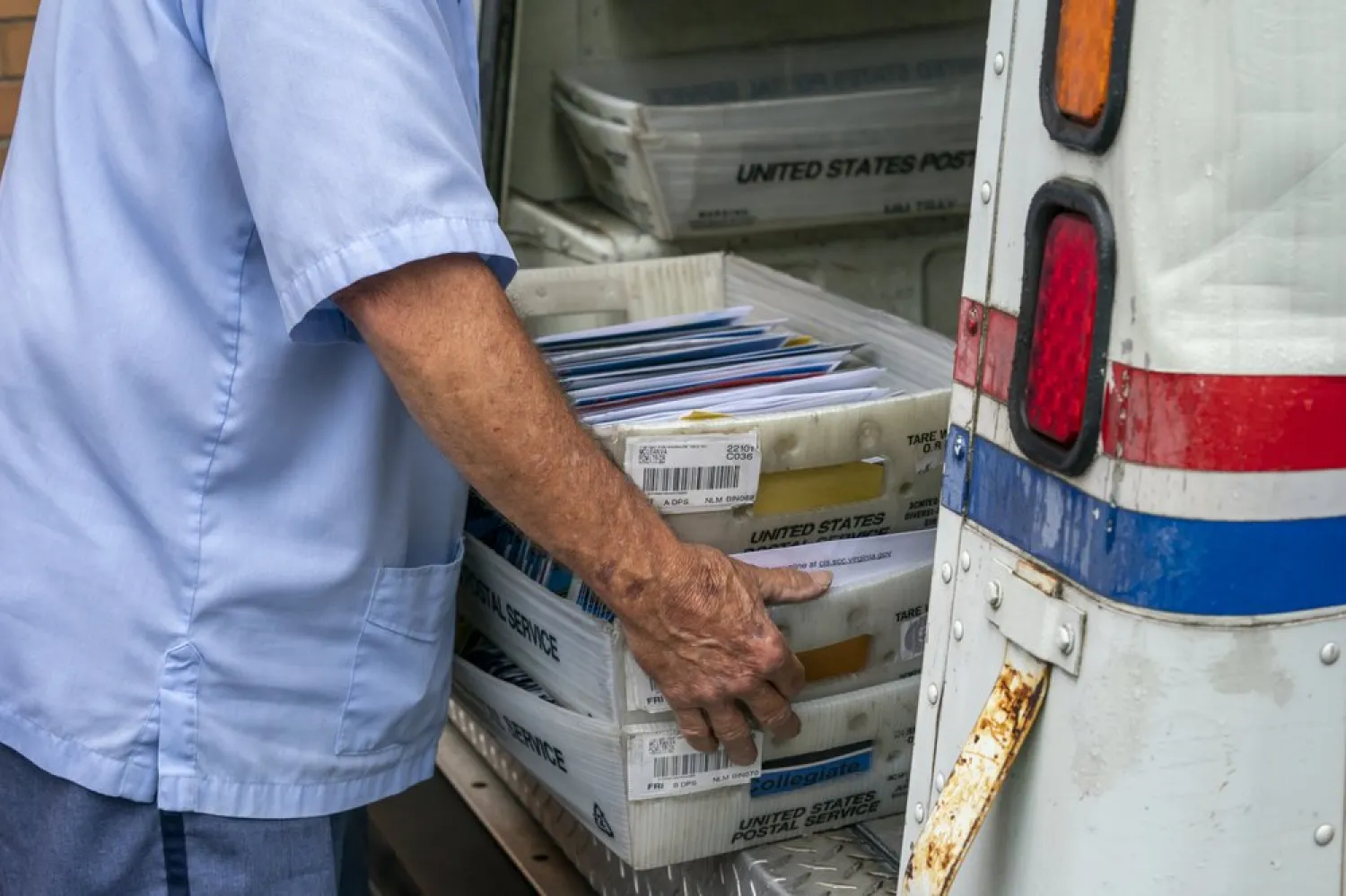 FILE - In this July 31, 2020, file photo, letter carriers load mail trucks for deliveries at a US Postal Service facility in McLean, Va. The success of the 2020 presidential election could come down to a most unlikely government agency: the US Postal Service. (AP Photo/J. Scott Applewhite, File)
