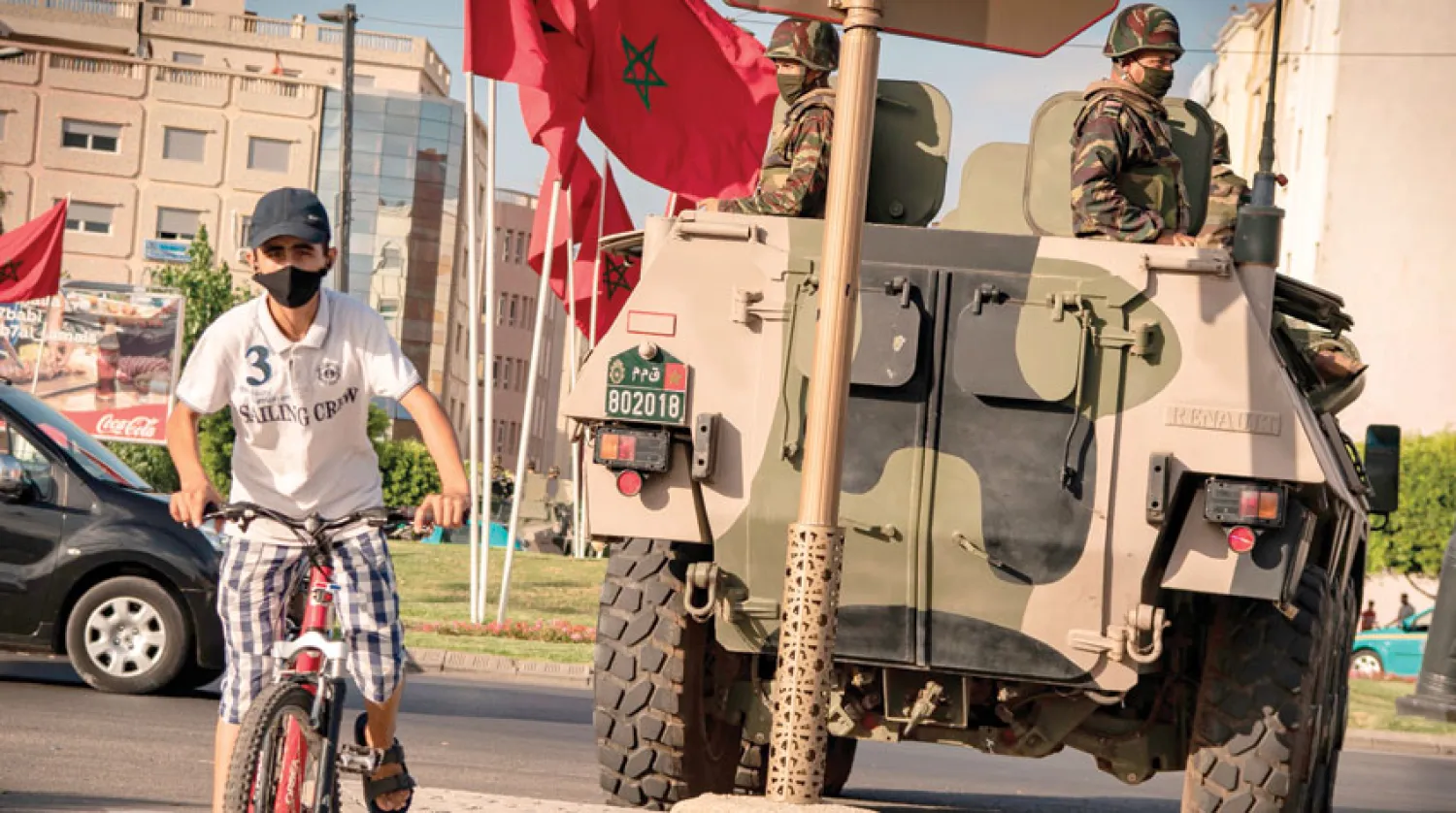 طفل يمر قرب دورية أمنية لتطبيق إجراءات «كوفيد - 19» في طنجة االثلاثاء (أ.ف.ب)