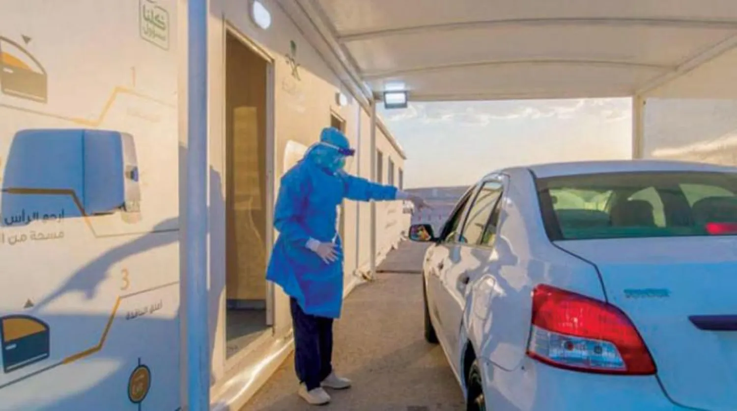 Bir vatandaşa koronavirüs testi yapmaya hazırlanan sağlık çalışanı (Şarku’l Avsat)