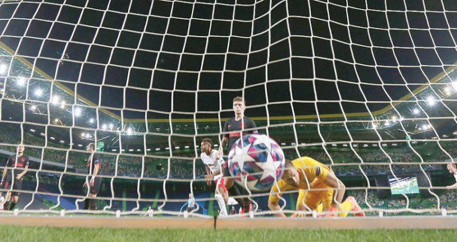 أوبلاك حارس أتلتيكو ينظر متحسراً لكرة آدامز لاعب لايبزيغ  وهي تسكن شباكه (رويترز)